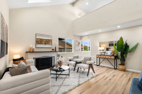 a living room with furniture a potted plant and a fireplace