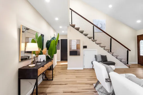 a living room with wooden floor furniture and a potted plant