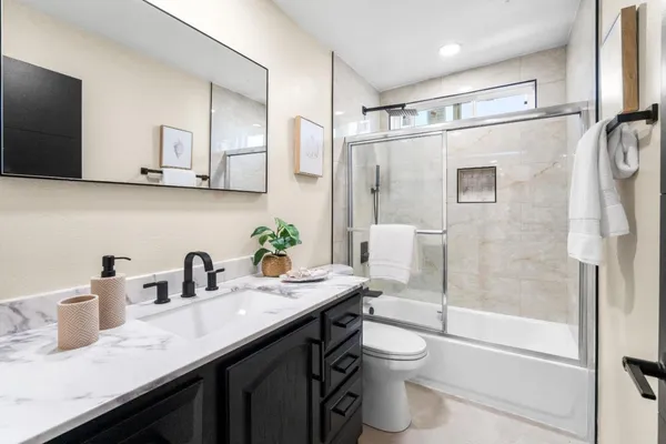 a bathroom with a granite countertop sink toilet and shower