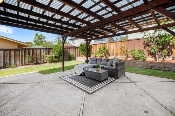 a living room with patio furniture and a garden