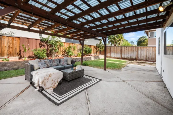 a living room with patio furniture and a garden