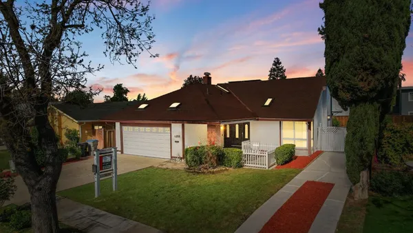 a view of a house with backyard and a tree