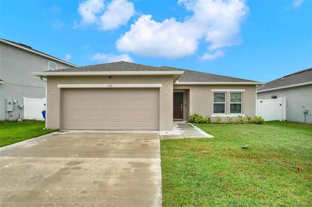 a view of a house with a yard and garage