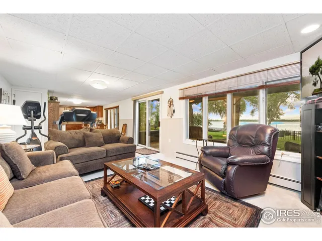 a view of a dining room with furniture a chandelier and kitchen view