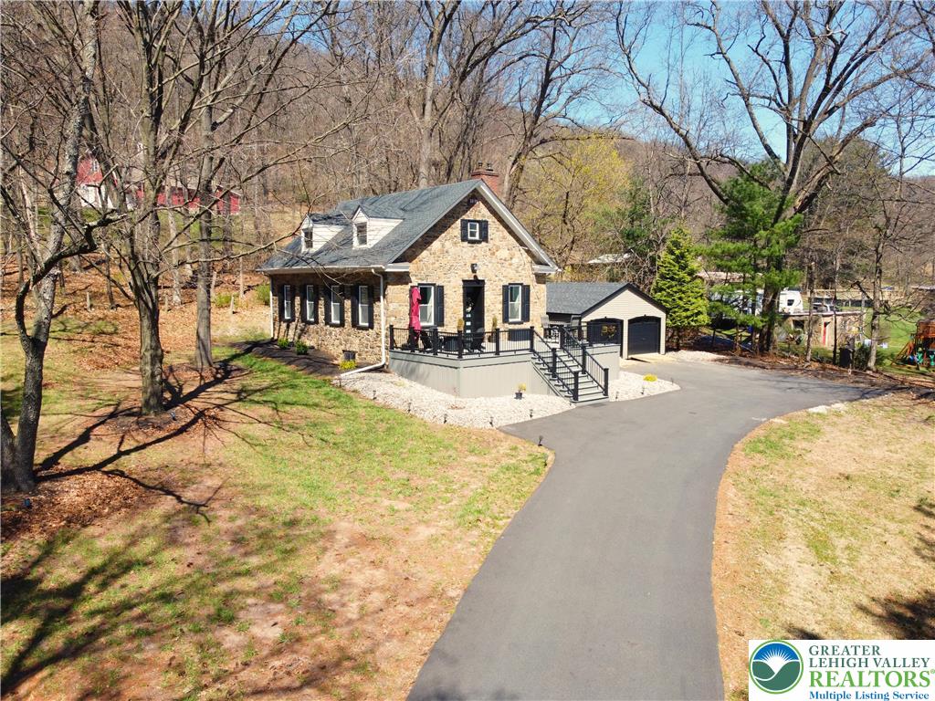 a front view of house with large trees