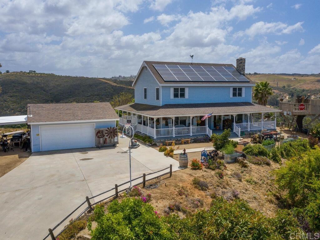 an aerial view of a house with yard and balcony
