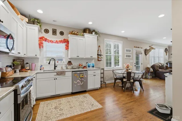 a kitchen with kitchen island granite countertop a sink window and cabinets