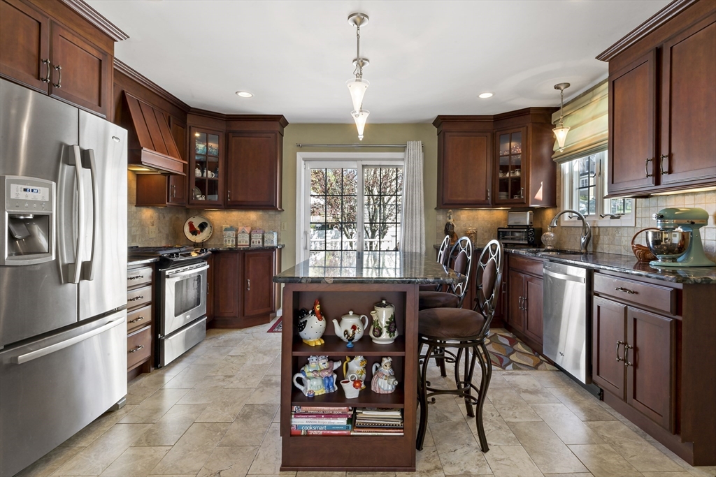 34 Howland Street Fall River, MA 02724 - Photo 11 of 42 a kitchen with stainless steel appliances granite countertop table chairs sink refrigerator and cabinets