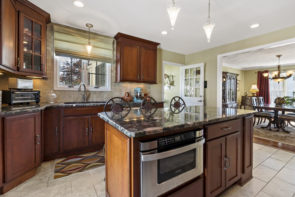 34 Howland Street Fall River, MA 02724 - Photo 13 of 42 a kitchen with granite countertop stainless steel appliances a sink stove and cabinets