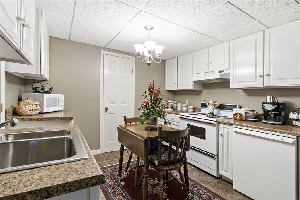 34 Howland Street Fall River, MA 02724 - Photo 37 of 42 a kitchen with granite countertop a sink stove and white cabinets