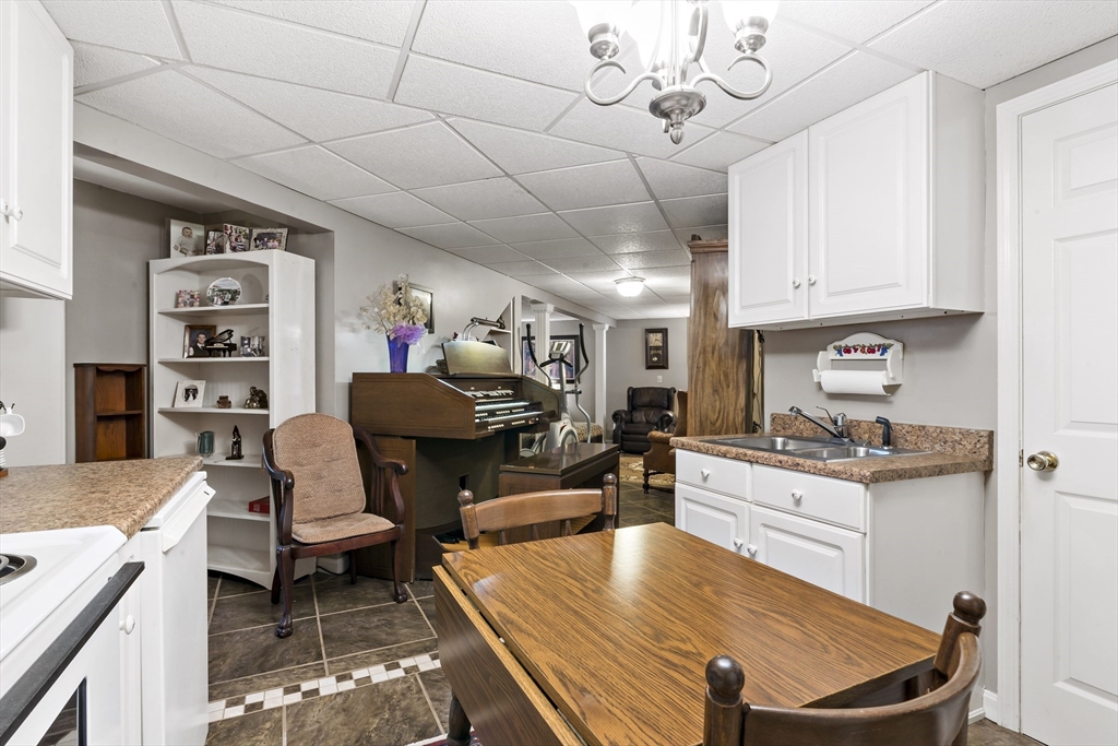 34 Howland Street Fall River, MA 02724 - Photo 38 of 42 a kitchen with stainless steel appliances kitchen island granite countertop a table chairs in it and a wooden floors