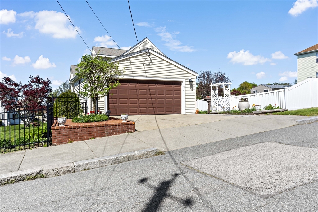34 Howland Street Fall River, MA 02724 - Photo 4 of 42 a front view of a house with a yard and garage