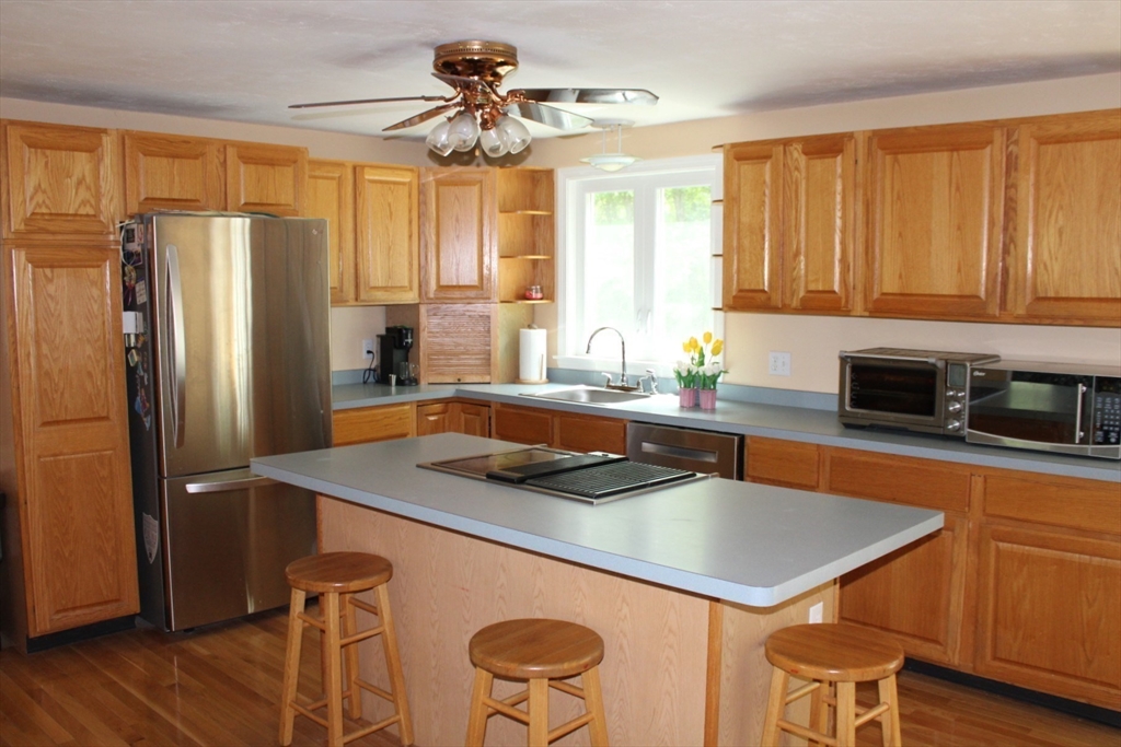 27 Gretchen Way Raynham, MA 02767 - Photo 4 of 20 a kitchen with stainless steel appliances granite countertop a sink a stove and a refrigerator