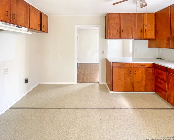 a kitchen with a sink a window and cabinets