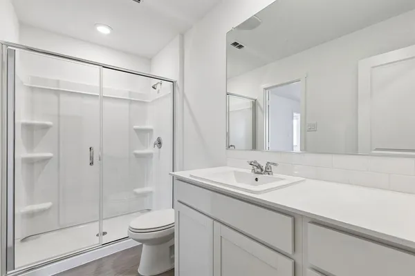 a bathroom with a sink a toilet and shower