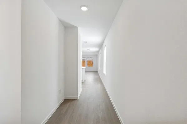 a view of a hallway with wooden floor