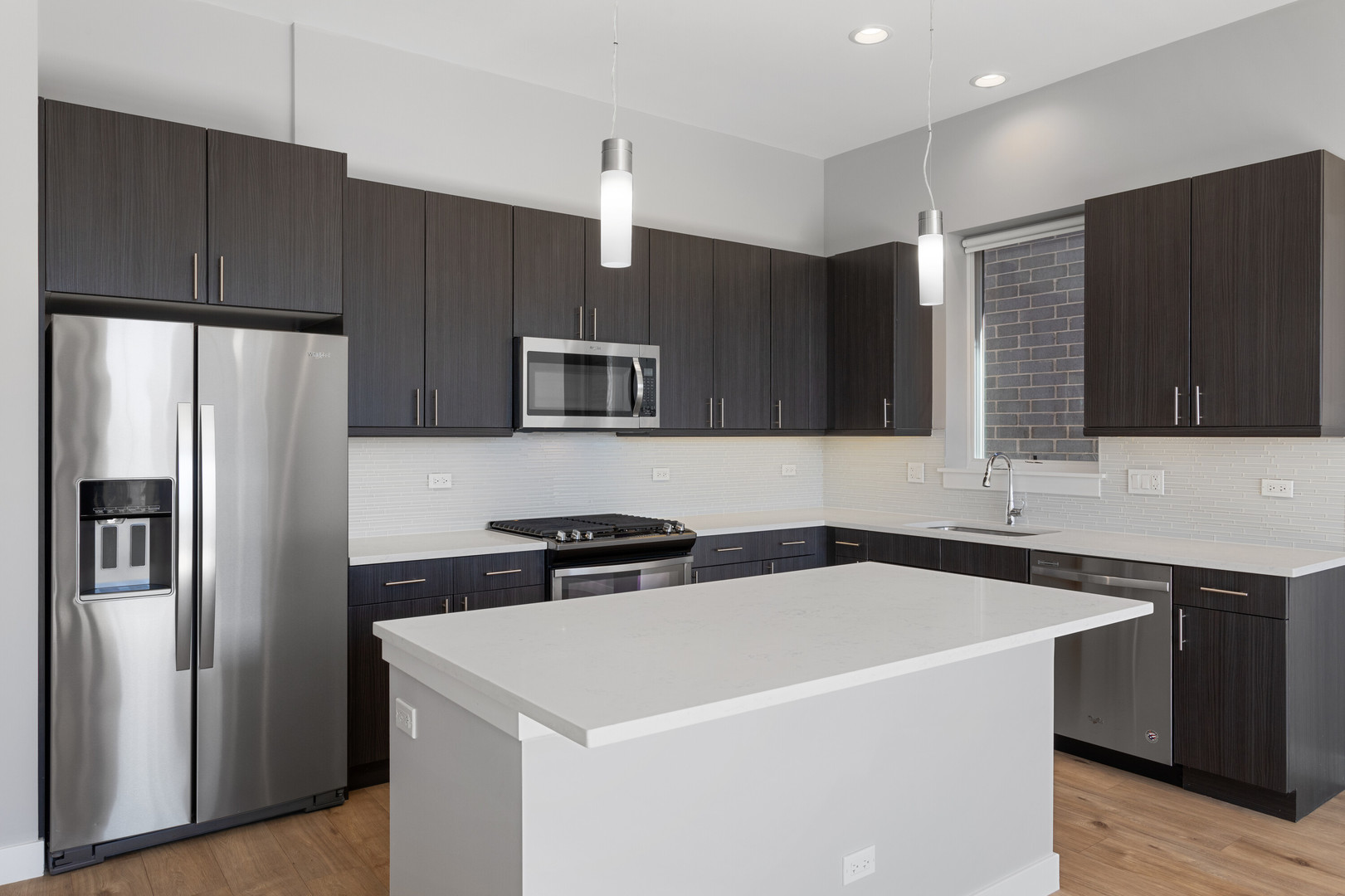 2518 West Addison Street, Unit 3W Chicago, IL 60618 - Photo 3 of 23 a kitchen with stainless steel appliances a refrigerator a sink a stove a microwave and wooden cabinets