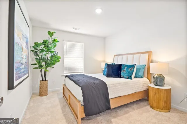 a bedroom with a bed and a potted plant