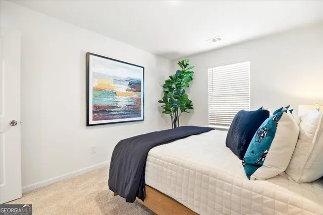 a bedroom with a bed and a painting on the wall