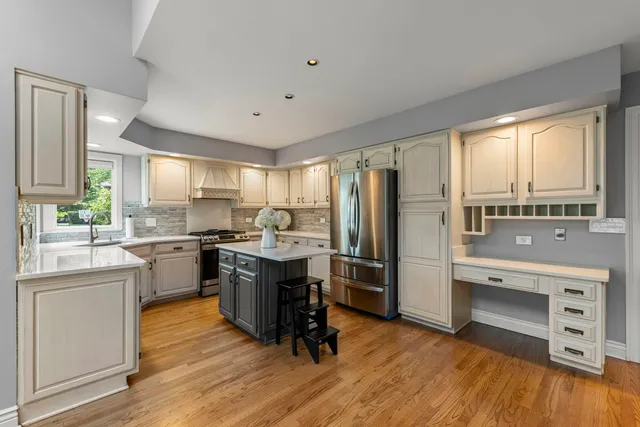 a kitchen with a refrigerator a sink dishwasher with a dining table and chairs