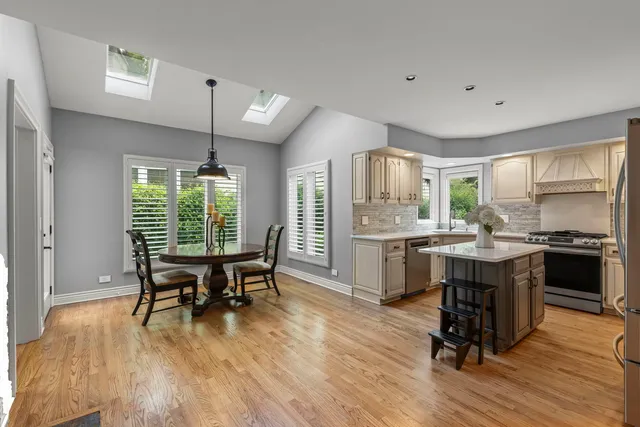 a kitchen with kitchen island granite countertop wooden floors and stainless steel appliances