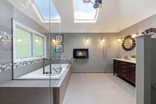 a bathroom with a sink a large mirror and a bathtub