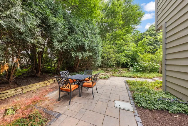a backyard of a house with fountain table and chairs
