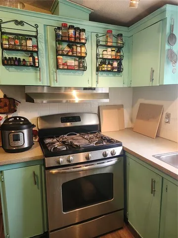 a stove top oven sitting inside of a kitchen