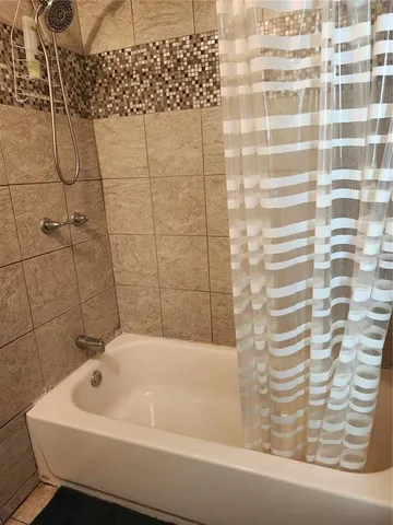 a bathroom with a bathtub and shower