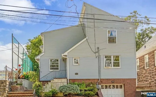 a view of a house with a yard and potted plants