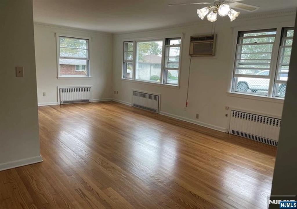 602 Studio Road Ridgefield, NJ 07657 - Photo 3 of 10 an empty room with wooden floor and windows