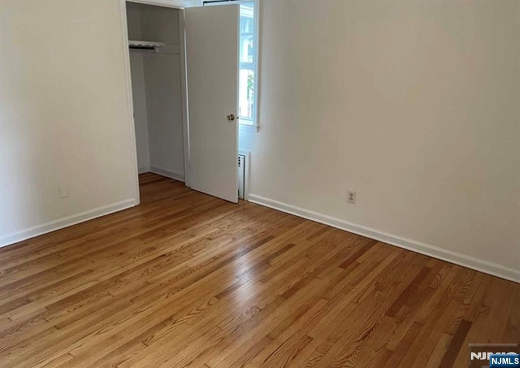 602 Studio Road Ridgefield, NJ 07657 - Photo 4 of 10 a view of an empty room with wooden floor and a window