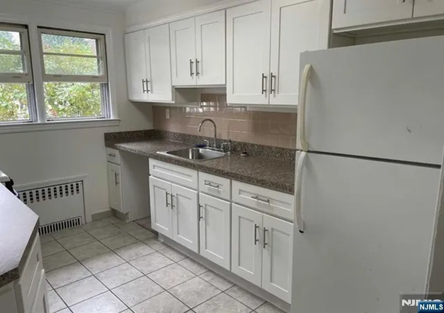 a kitchen with a refrigerator sink and cabinets