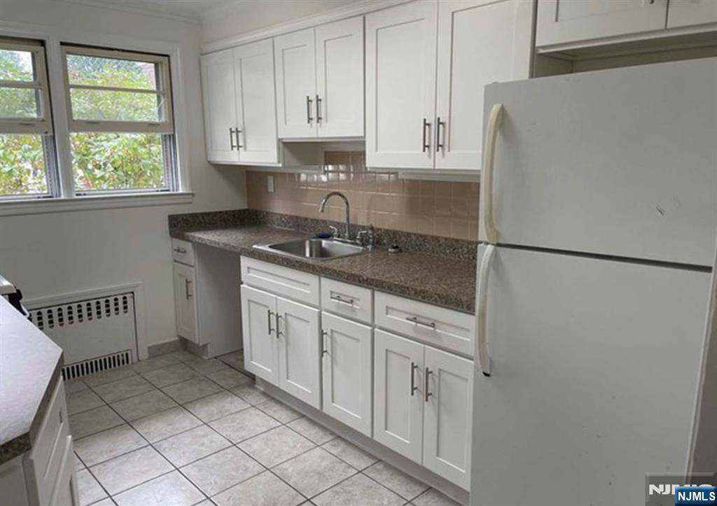 602 Studio Road Ridgefield, NJ 07657 - Photo 5 of 10 a kitchen with a refrigerator sink and cabinets