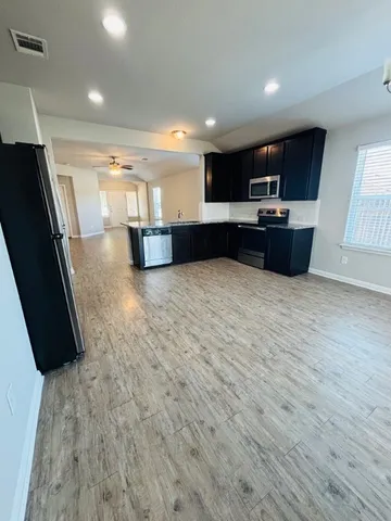 an empty room with wooden floor and windows