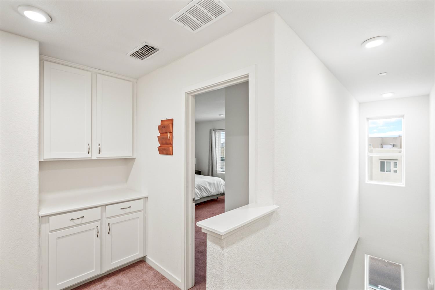 4174 Sally Ride Way Sacramento, CA 95834 - Photo 37 of 38 a hallway with white cabinets and white appliances