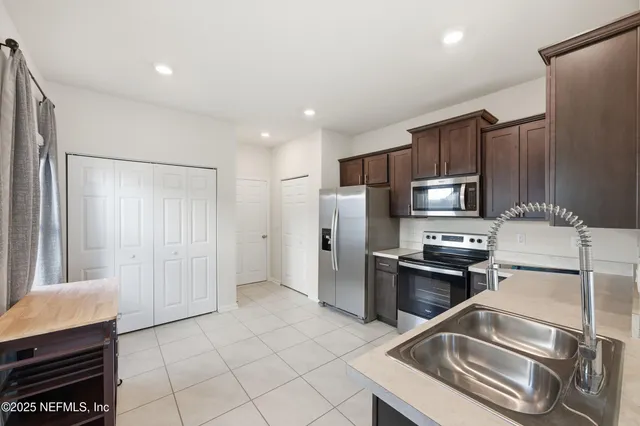 a kitchen with stainless steel appliances granite countertop a refrigerator and a stove top oven