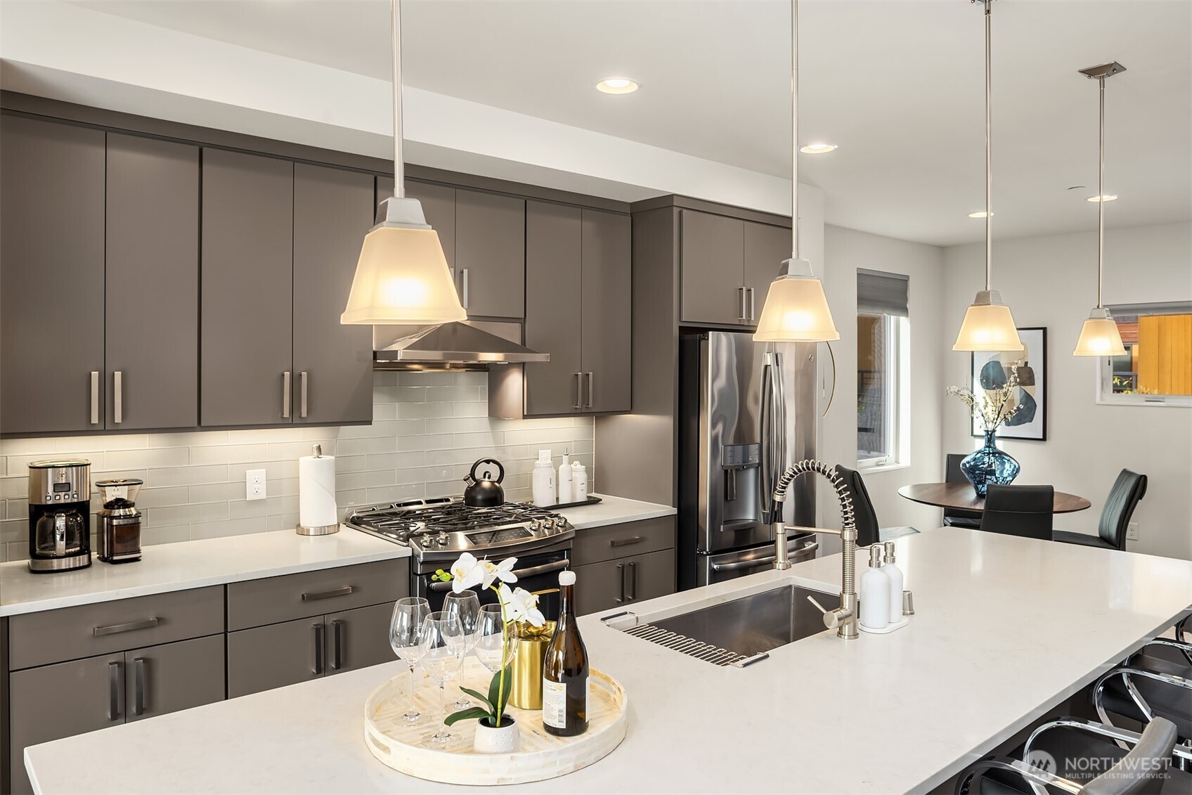3300 Northeast 65th Street, Unit 211 Seattle, WA 98115 - Photo 7 of 15 a kitchen with a sink a stove and chairs