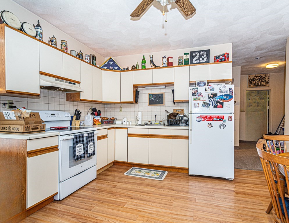 98 Margin Street Salem, MA 01970 - Photo 11 of 17 a kitchen with a refrigerator a stove top oven a sink and cabinets