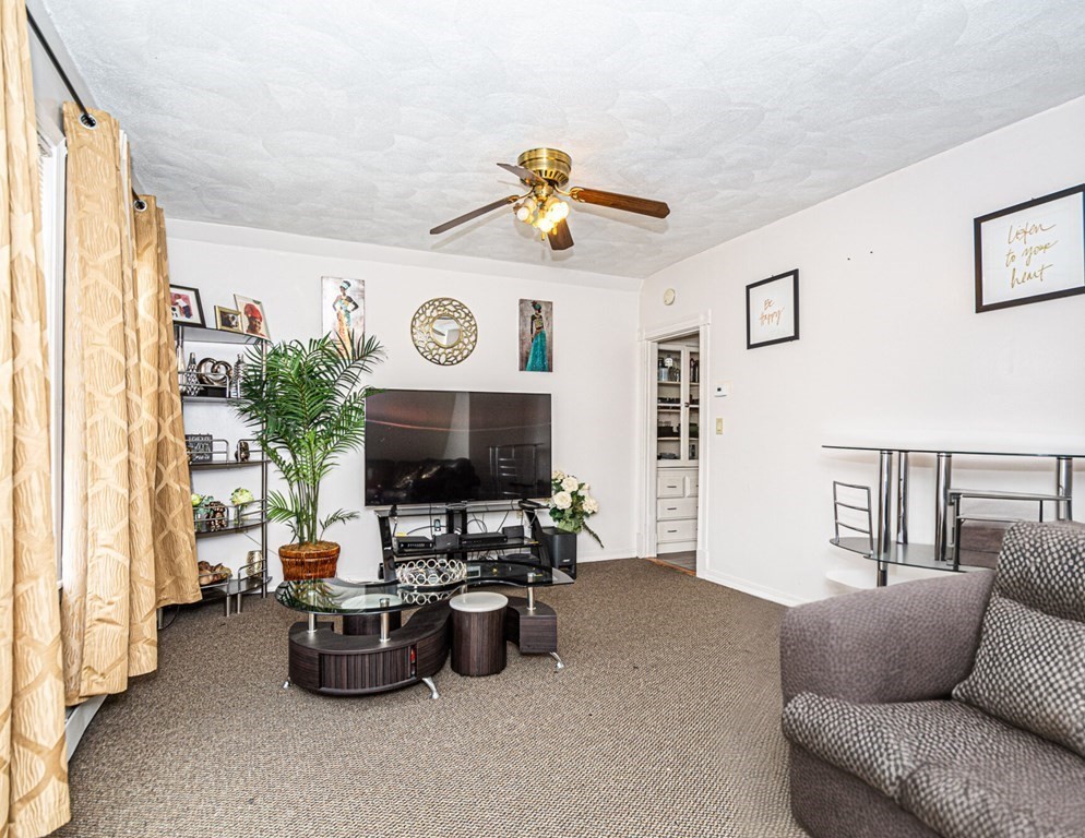 98 Margin Street Salem, MA 01970 - Photo 15 of 17 a living room with furniture a clock on the wall and a window