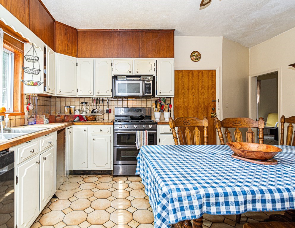 98 Margin Street Salem, MA 01970 - Photo 3 of 17 a kitchen with stainless steel appliances a sink window and cabinets
