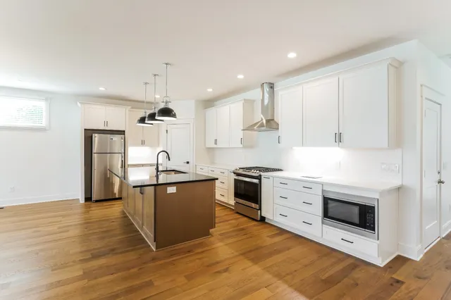 a kitchen with stainless steel appliances granite countertop a stove a sink and a refrigerator