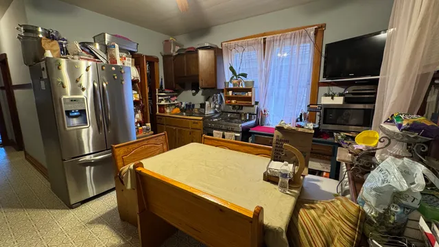 a kitchen with a refrigerator and a stove top oven