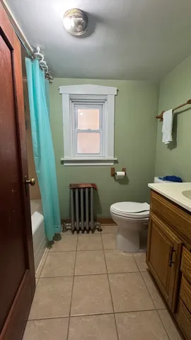 a bathroom with a toilet a sink a mirror and a shower