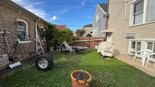 a view of a chair and table in backyard of the house