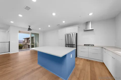 a view of kitchen with wooden floor and electronic appliances