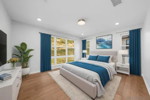 an empty room with wooden floor and fan