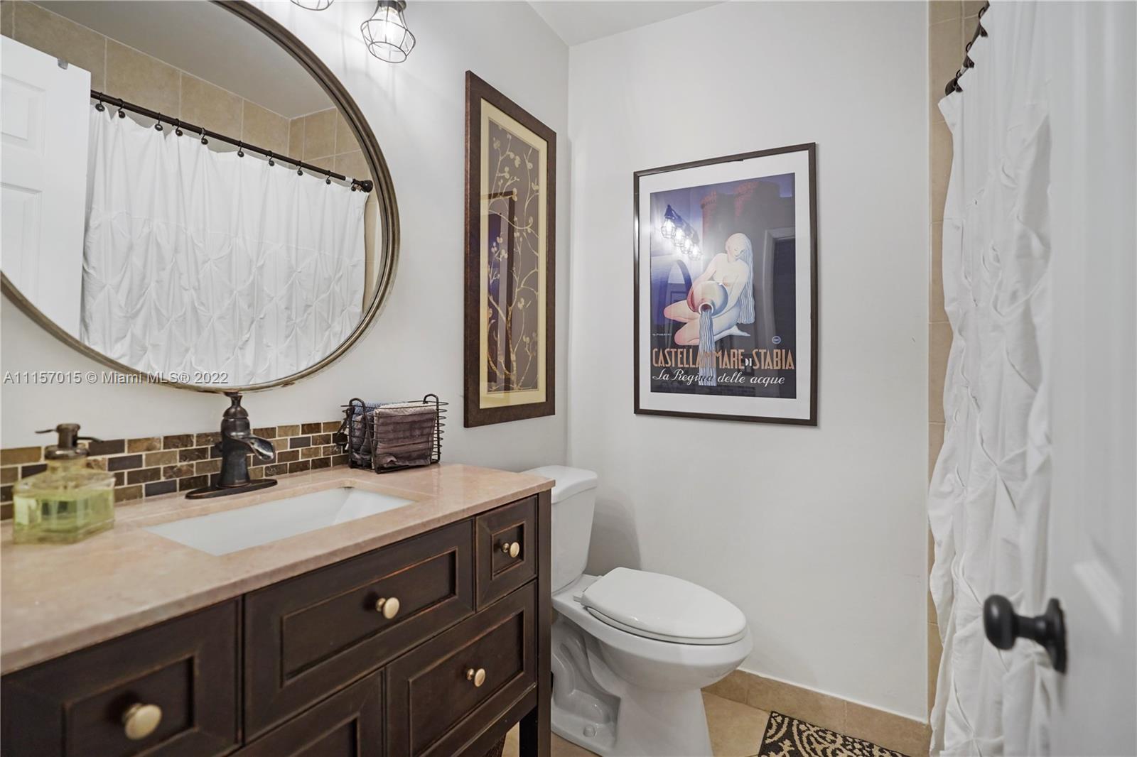 1089 Northwest 13th Street, Unit 6 Boca Raton, FL 33486 - Photo 11 of 32 a bathroom with a toilet a sink and mirror