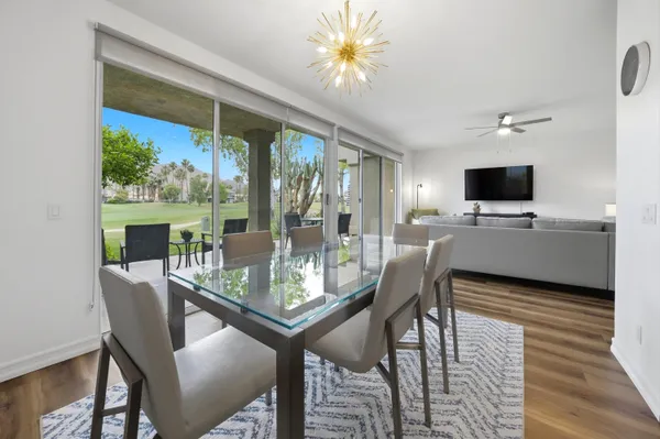 a view of a dining room with furniture a chandelier and wooden floor