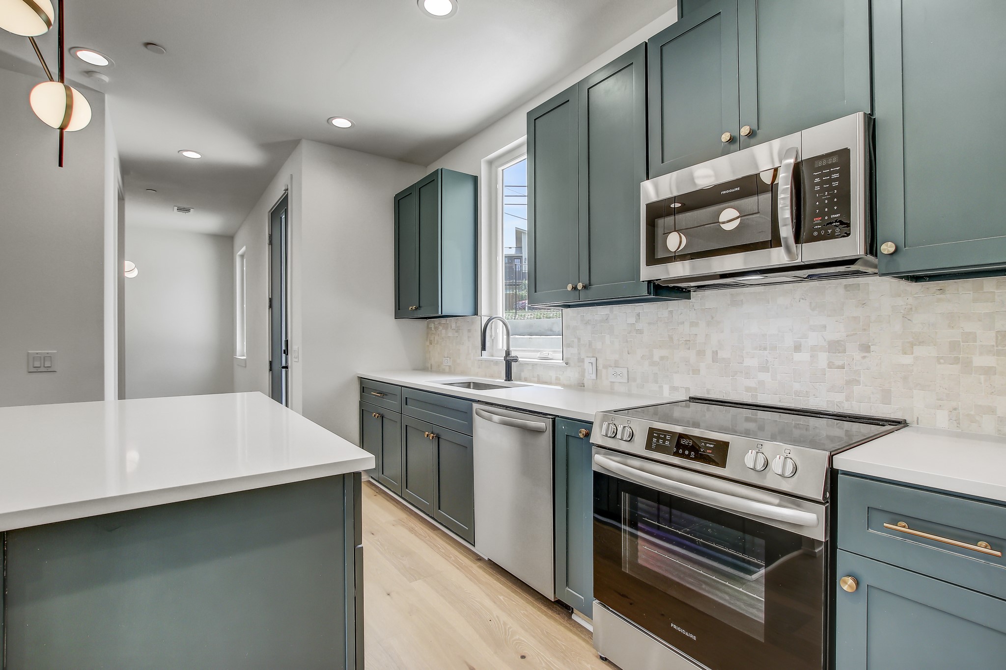 4127 East 12th Street, Unit 5 Austin, TX 78721 - Photo 13 of 33 Kitchen with stainless steel appliances, light wood finished floors, tasteful backsplash, a sink, and recessed lighting